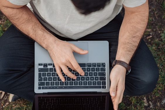 person in white shirt using macbook pro