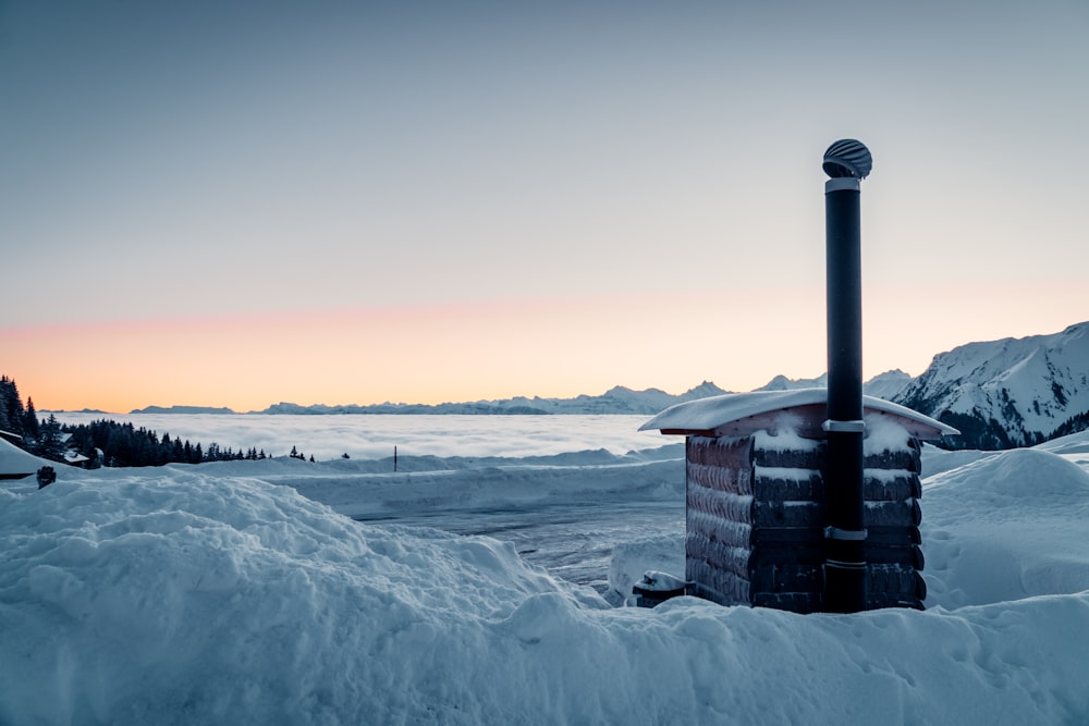 brown wooden house on snow covered ground during daytime