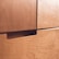 Close-up of a wooden 5-drawer chest with smooth handles and a warm finish.