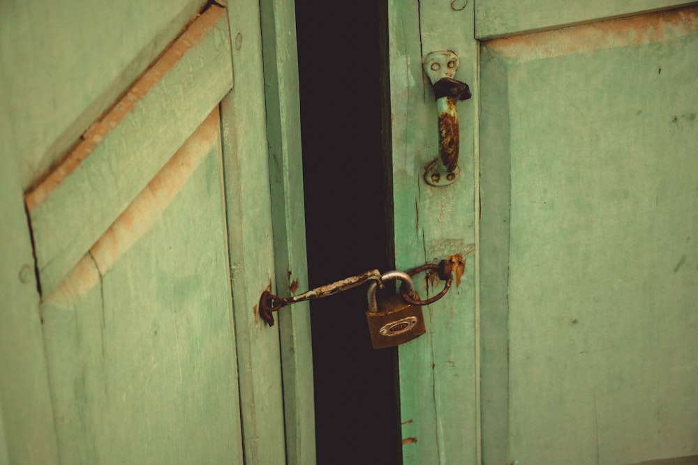 brown padlock on blue wooden door