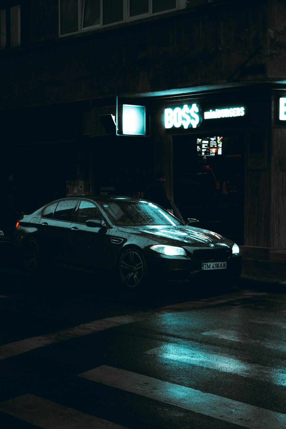 mercedes benz cupê preto estacionado ao lado do edifício durante a noite