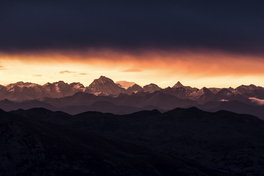 snow covered mountains during sunset