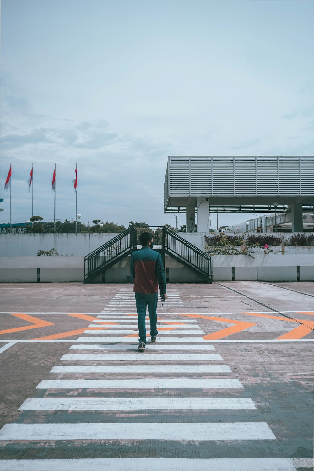 man in green jacket walking on pedestrian lane during daytime