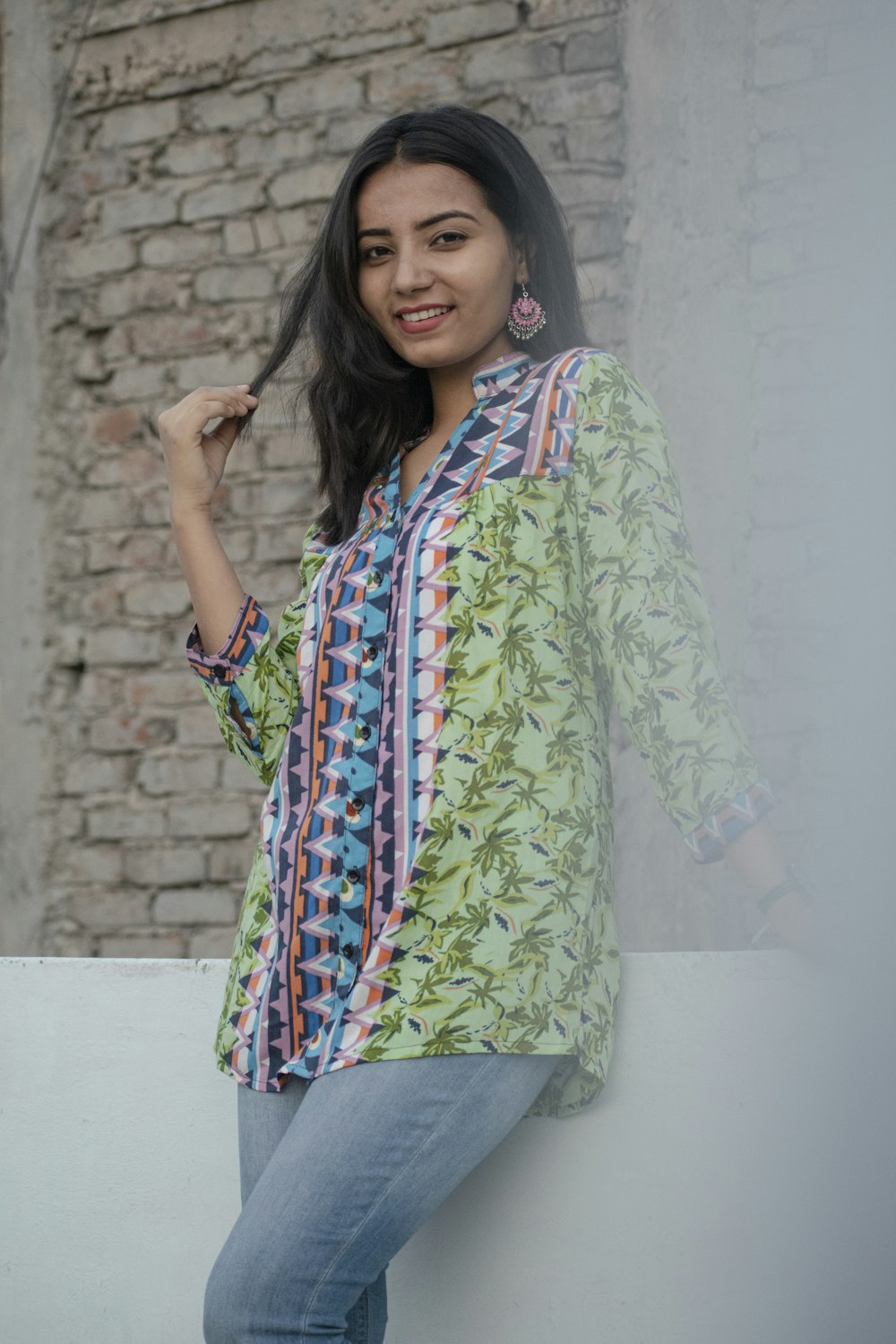 woman in green and white long sleeve shirt and blue denim jeans