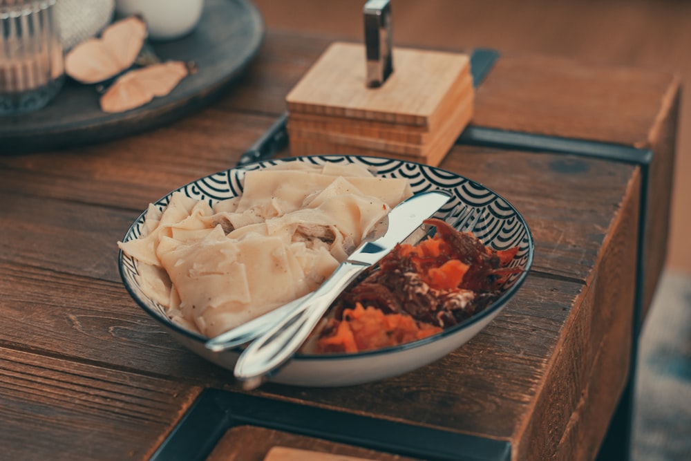 white and brown ceramic bowl on brown wooden table