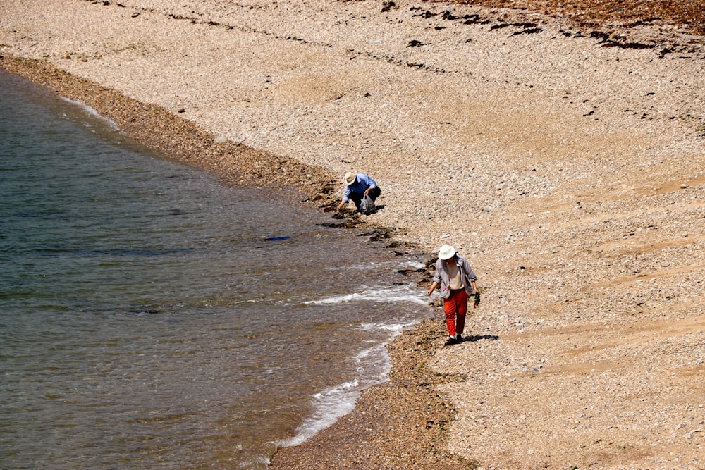 2 children walking on beach during daytime