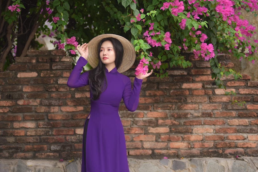 woman in purple long sleeve dress standing beside purple flowers