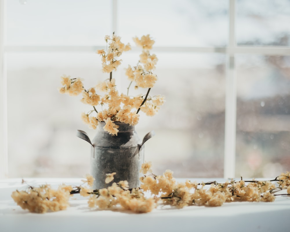 yellow flowers in gray steel bucket