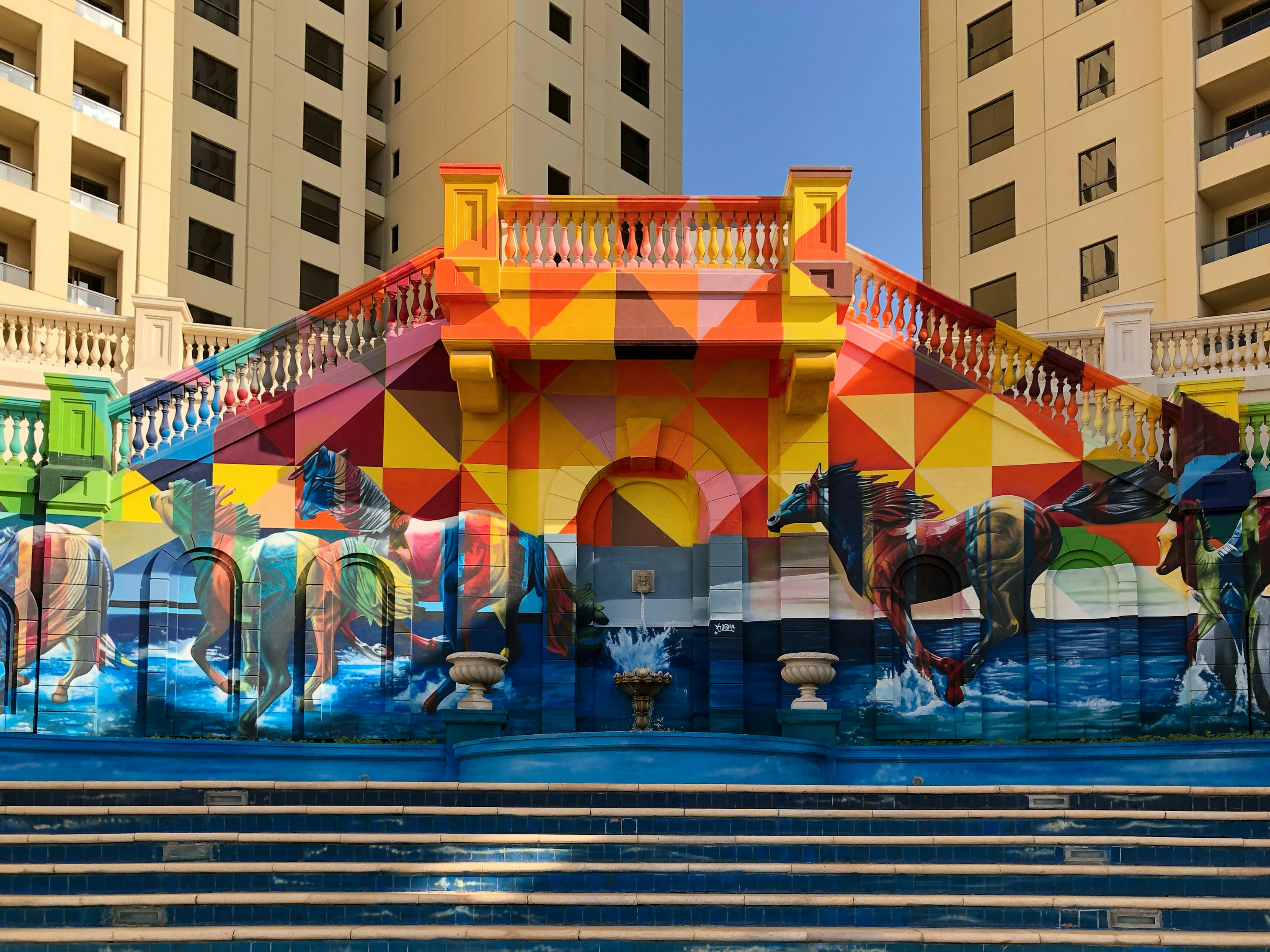 Stairs leading up to a mural of galloping horses at Jumeirah, Dubai.