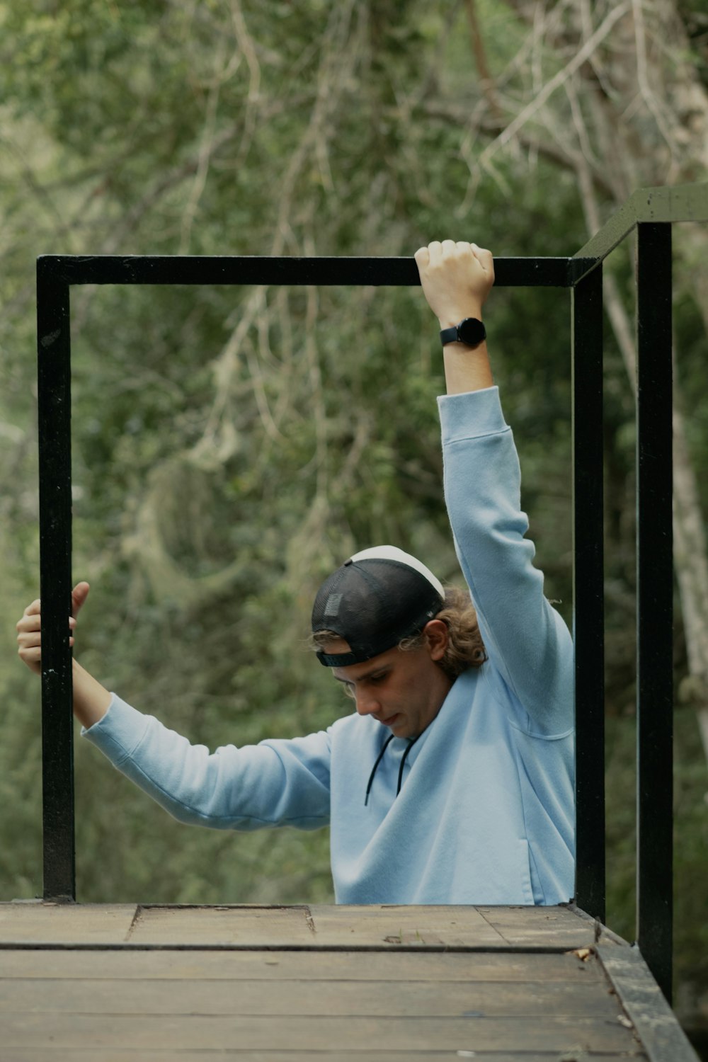 man in blue dress shirt wearing black helmet holding black metal bar