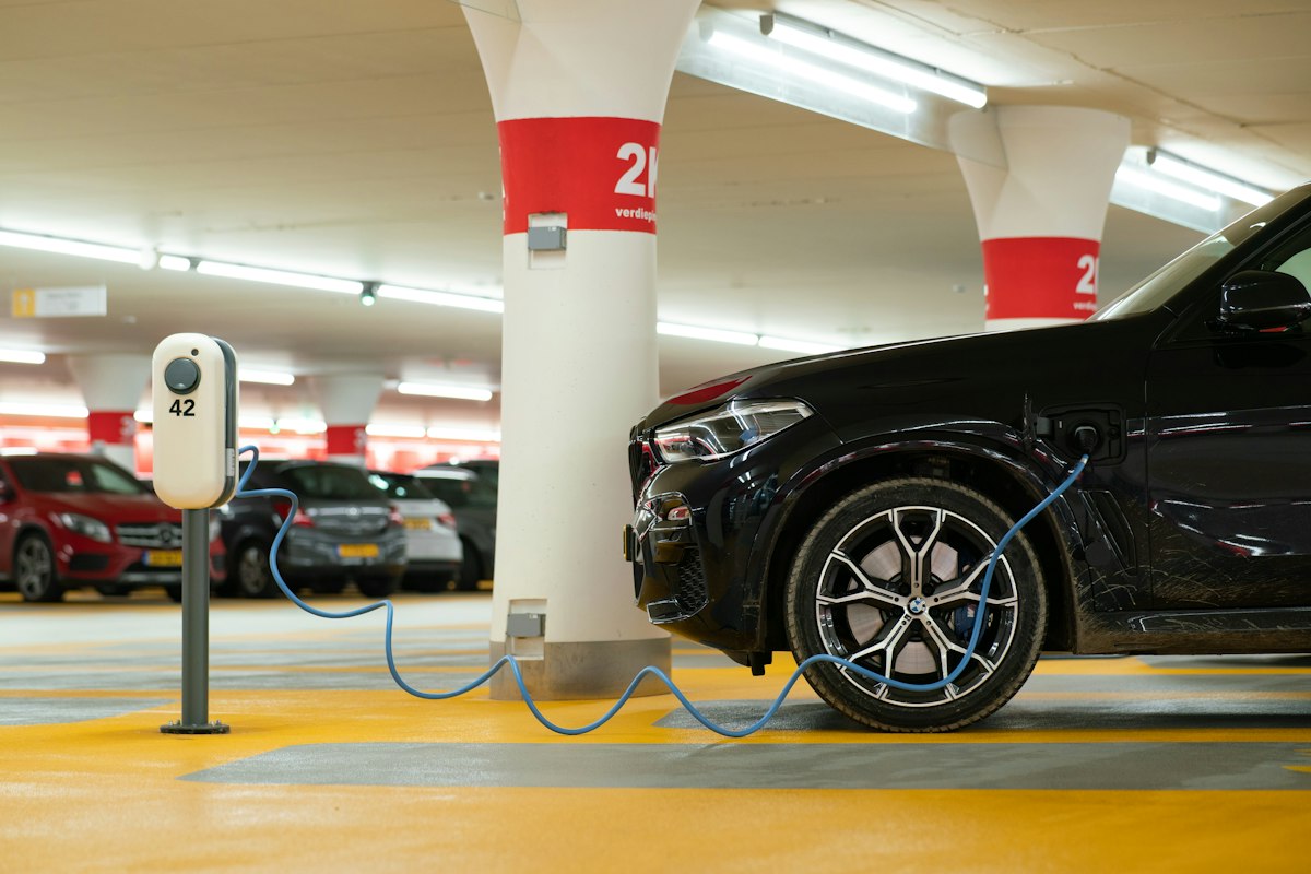 Schwarzes Elektroauto beim Laden auf einem Parkplatz