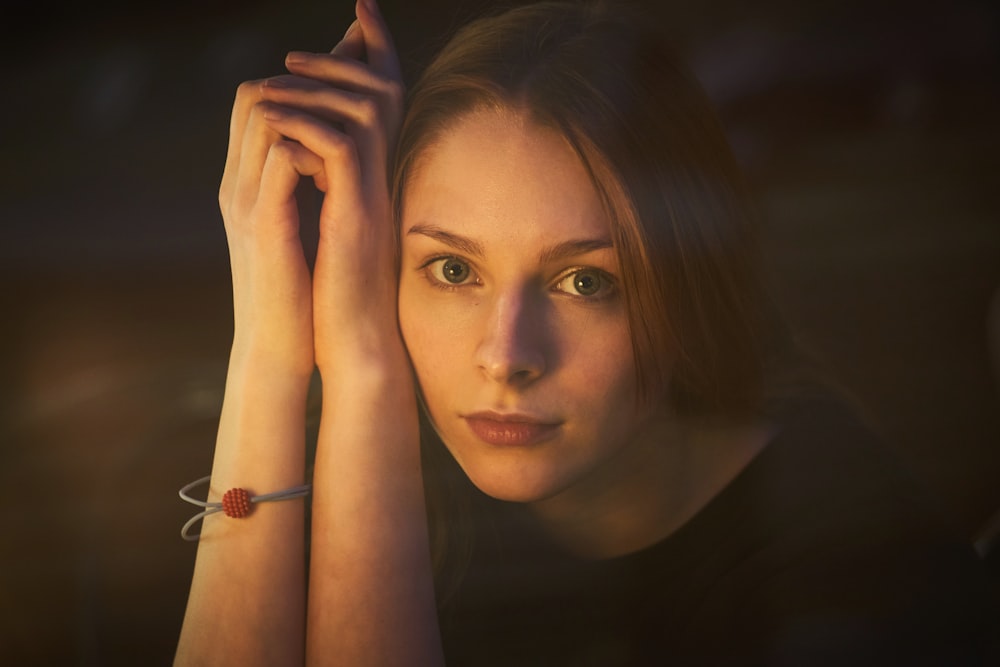 woman with brown hair holding her face