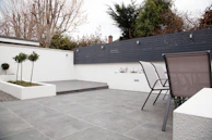 A beautifully finished concrete patio with clean lines and tropical plants around, perfect for outdoor living.