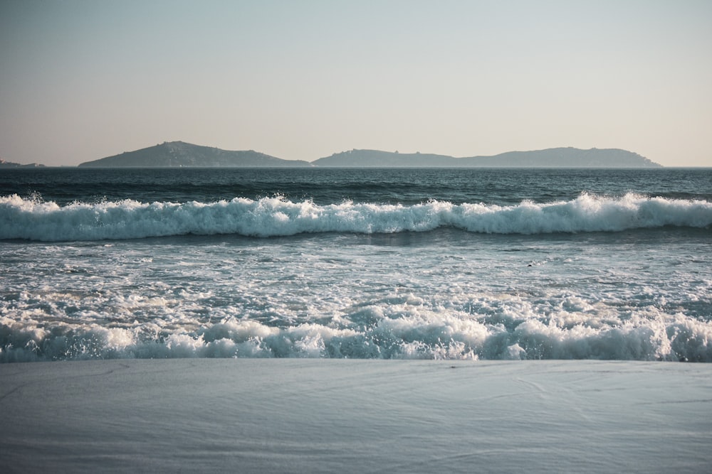 sea waves crashing on shore during daytime