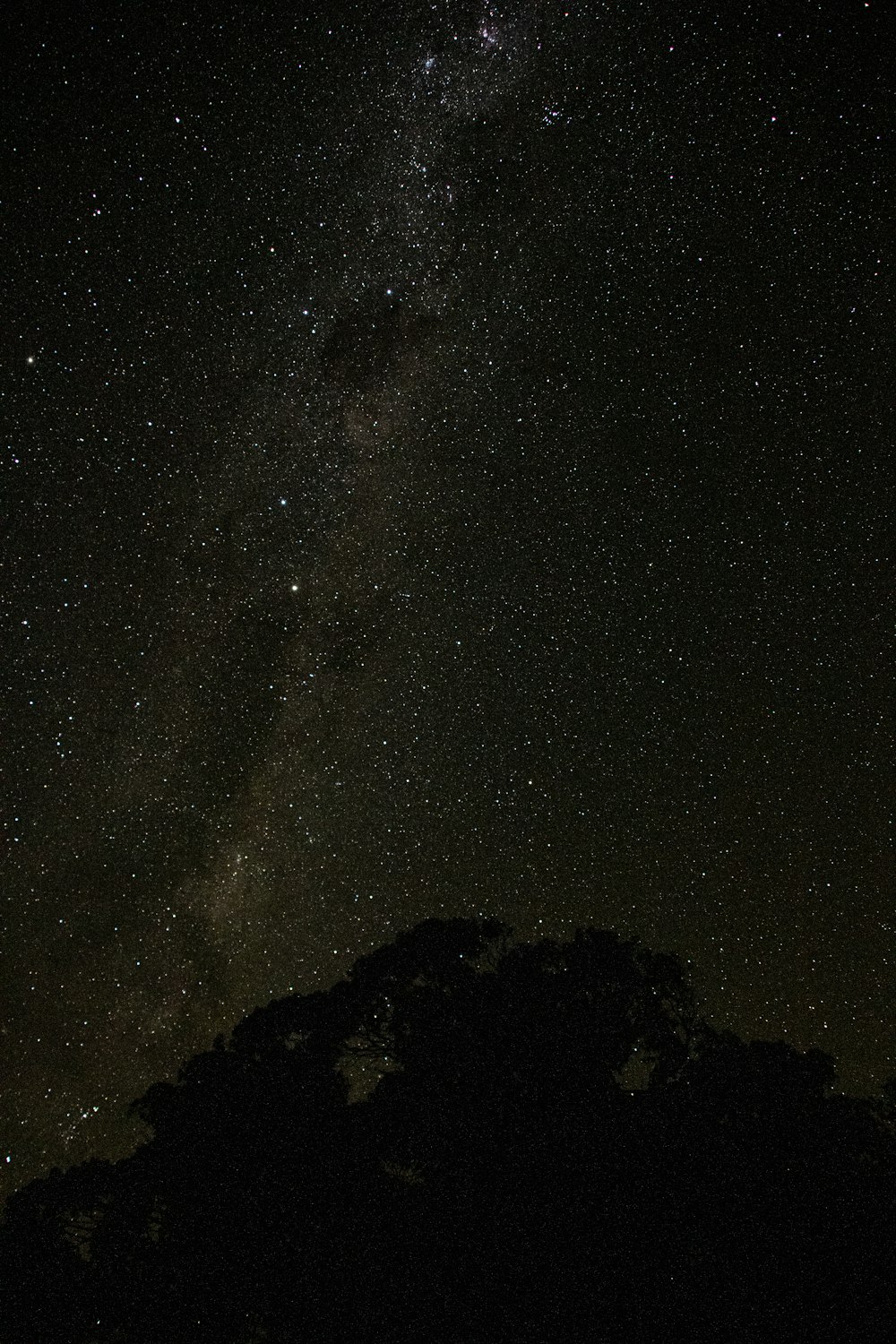 silhouette of mountain under starry night