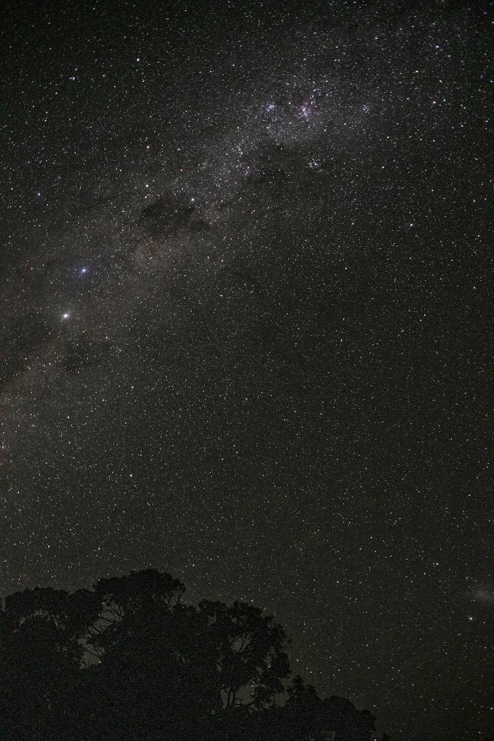 silhouette of mountain under starry night