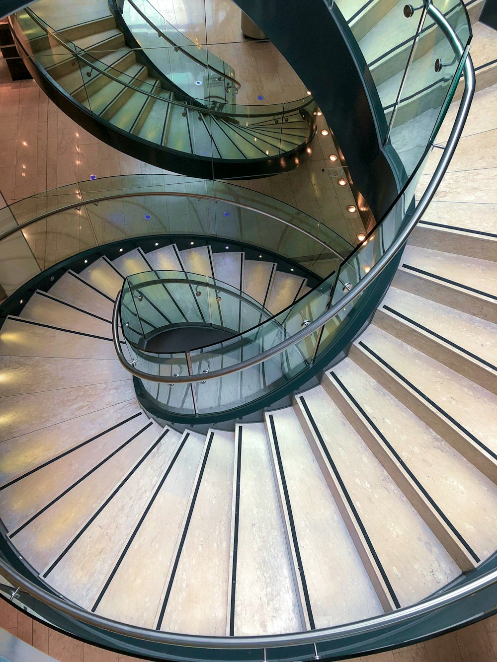 graue Wendeltreppe mit braunen Holzgeländern