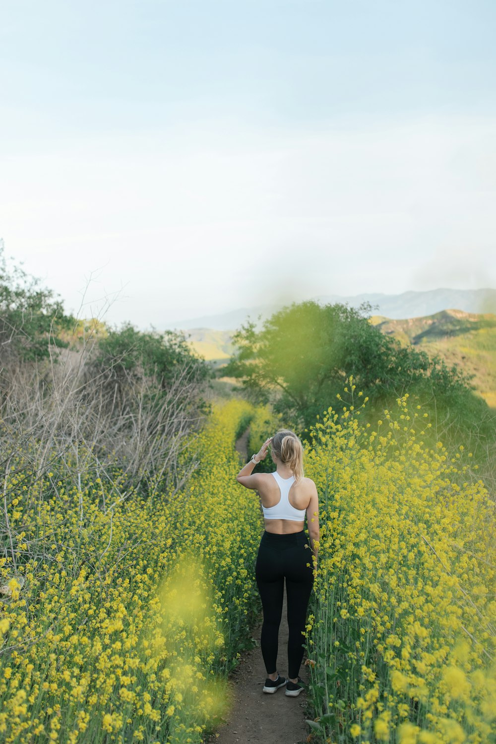 woman in black tank top standing on green grass field during daytime