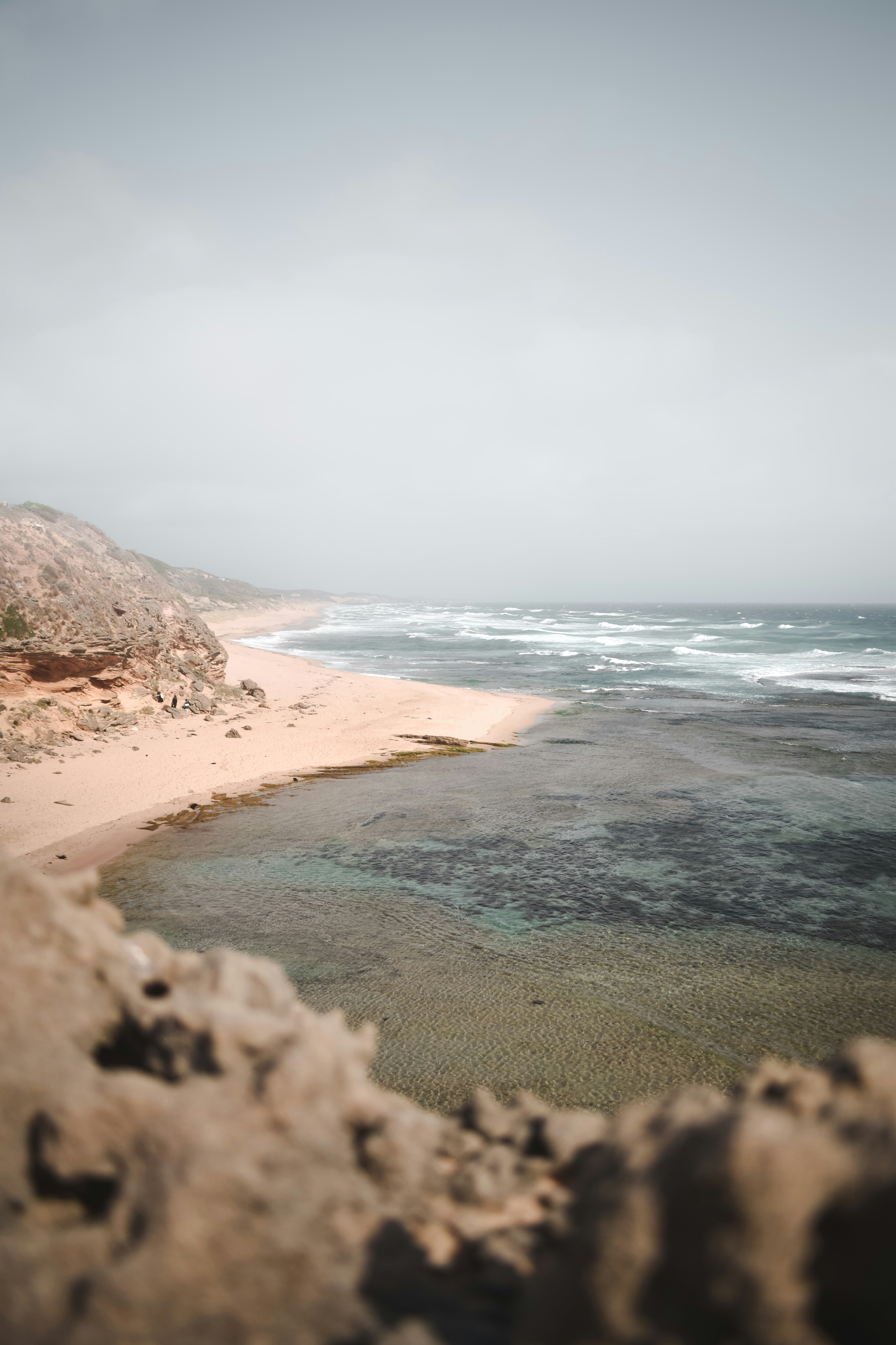 brown sand beach with brown sand and blue sea water during daytime