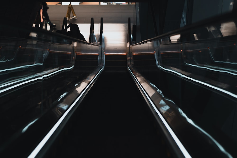people sitting on black and silver escalator
