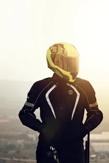 Close-up of a bright yellow matte motorcycle helmet resting on a black motorbike seat under natural sunlight.