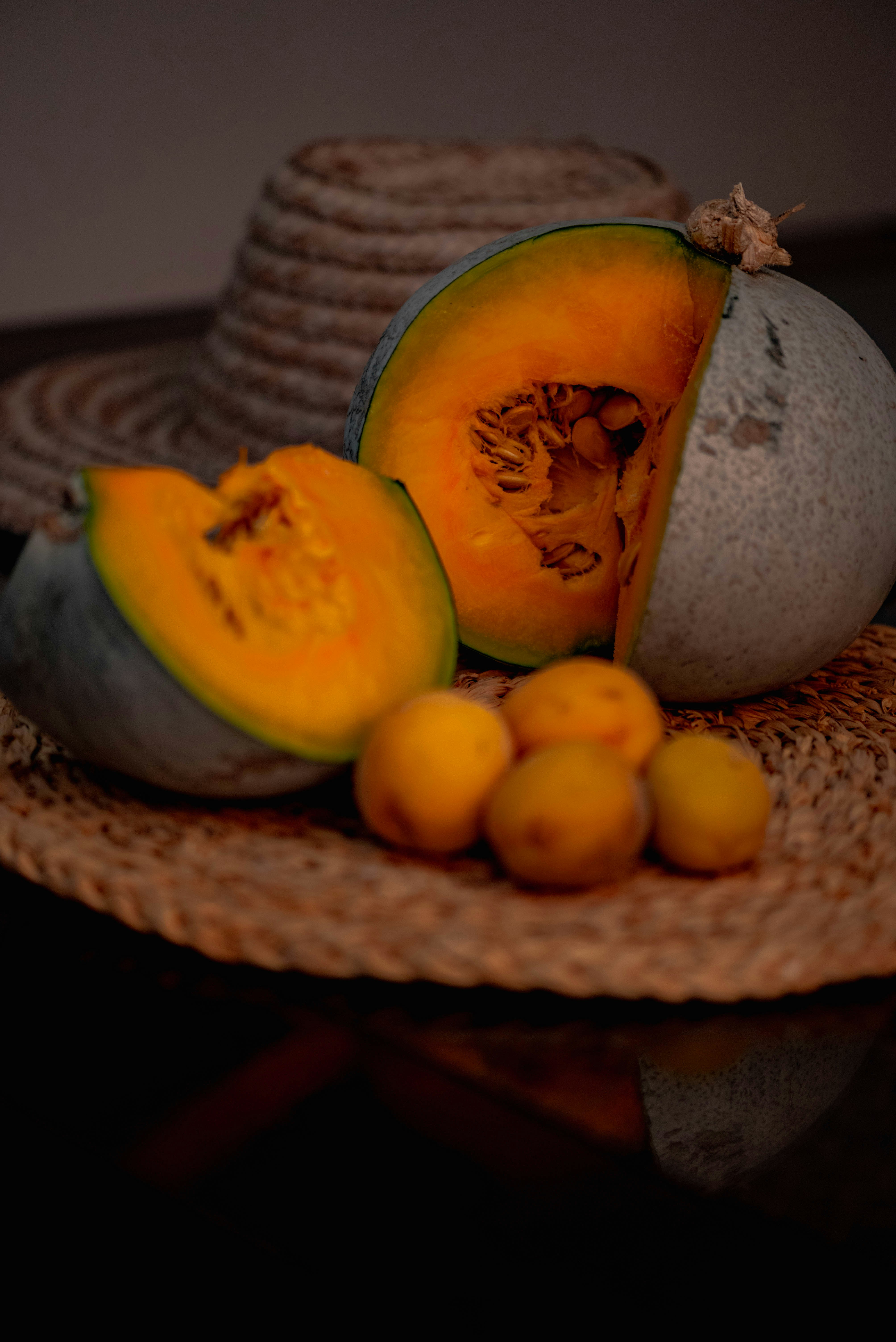 sliced watermelon and orange fruits on brown woven round basket