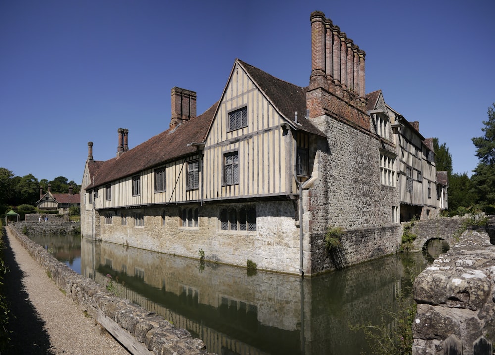 white and brown concrete building beside river under blue sky during daytime