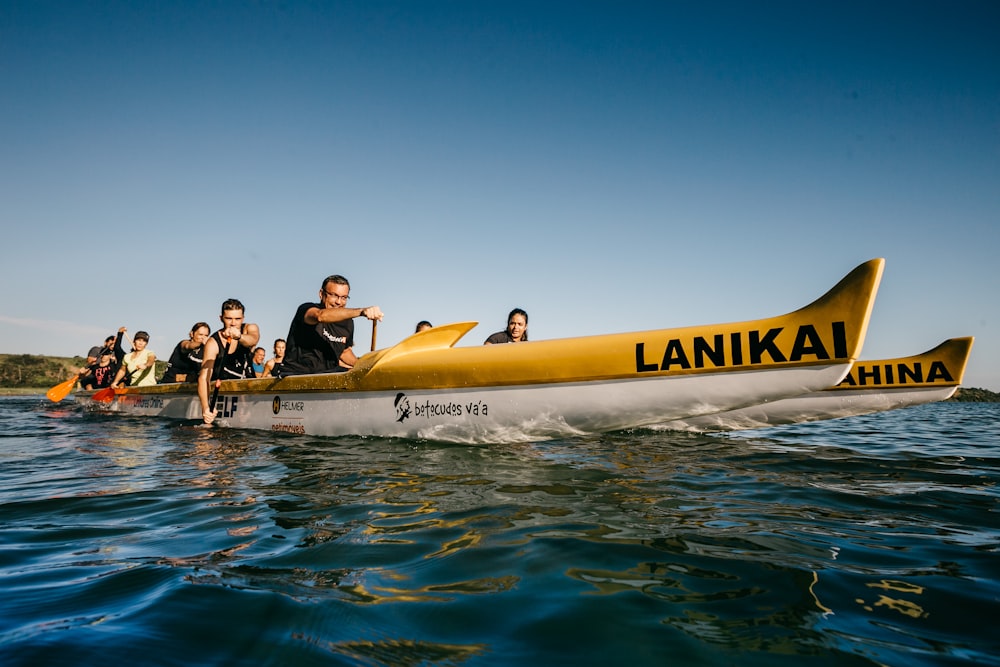 Menschen, die tagsüber mit dem gelben Bananenboot auf dem Wasser fahren