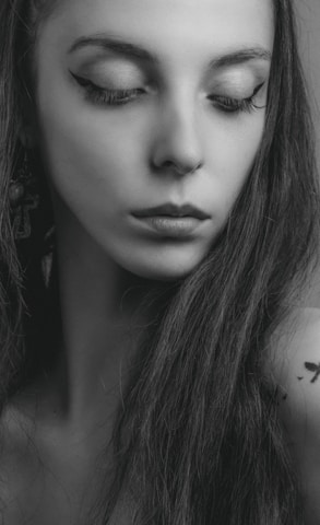 Realistic portrait tattoo of a woman with soft shading and fine lines on shoulder blade.