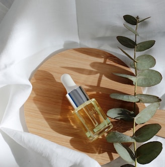 clear glass bottle on white textile