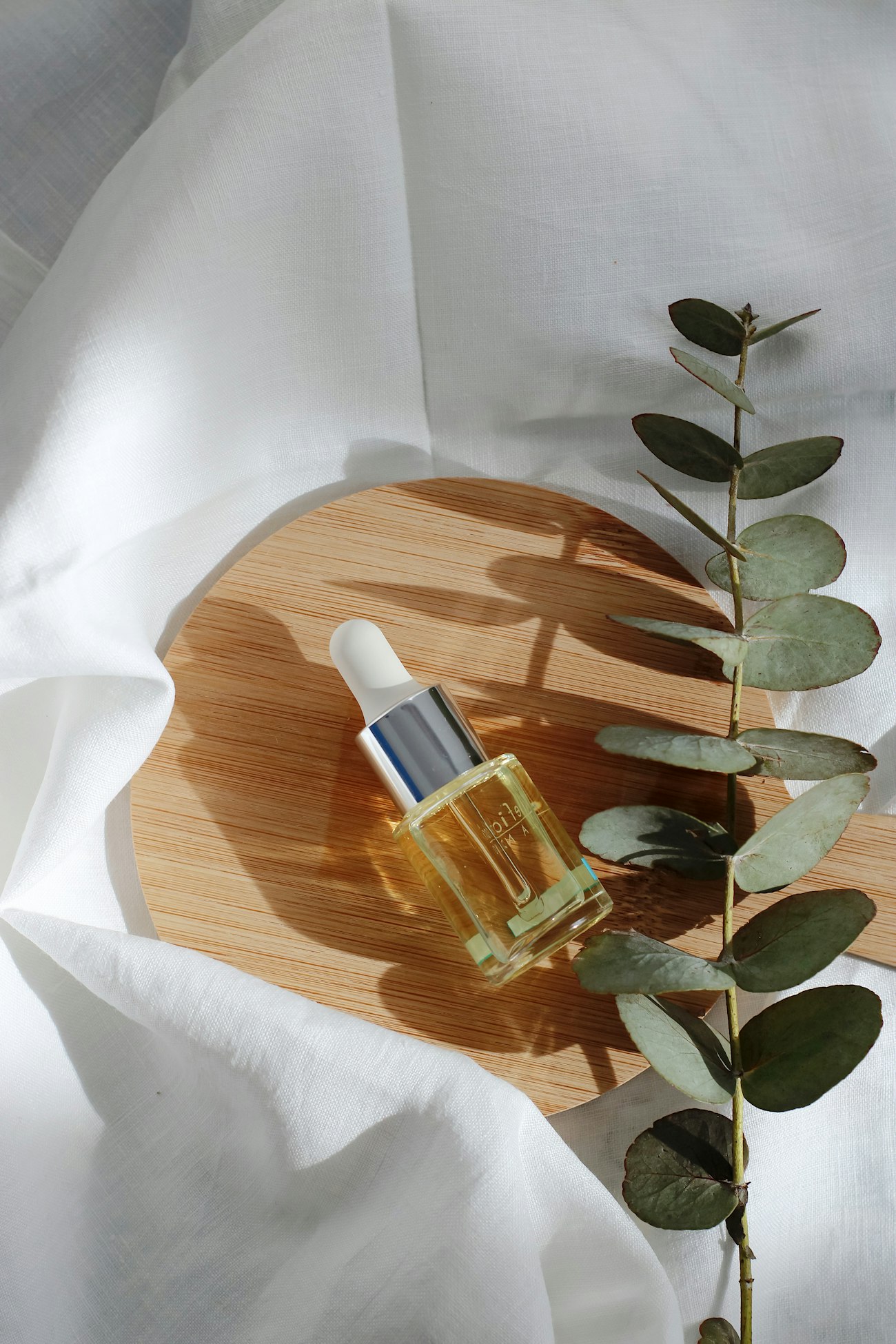 Flacon d'huile de parfum ambrée dans la lumière du matin