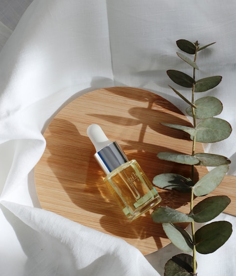 clear glass bottle on white textile