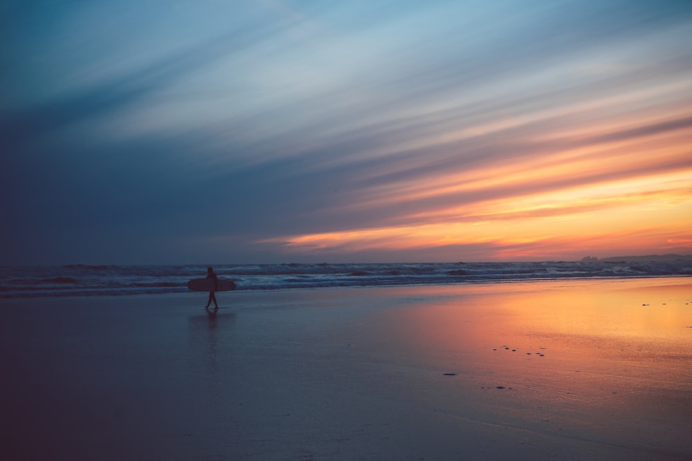 person in body of water during sunset