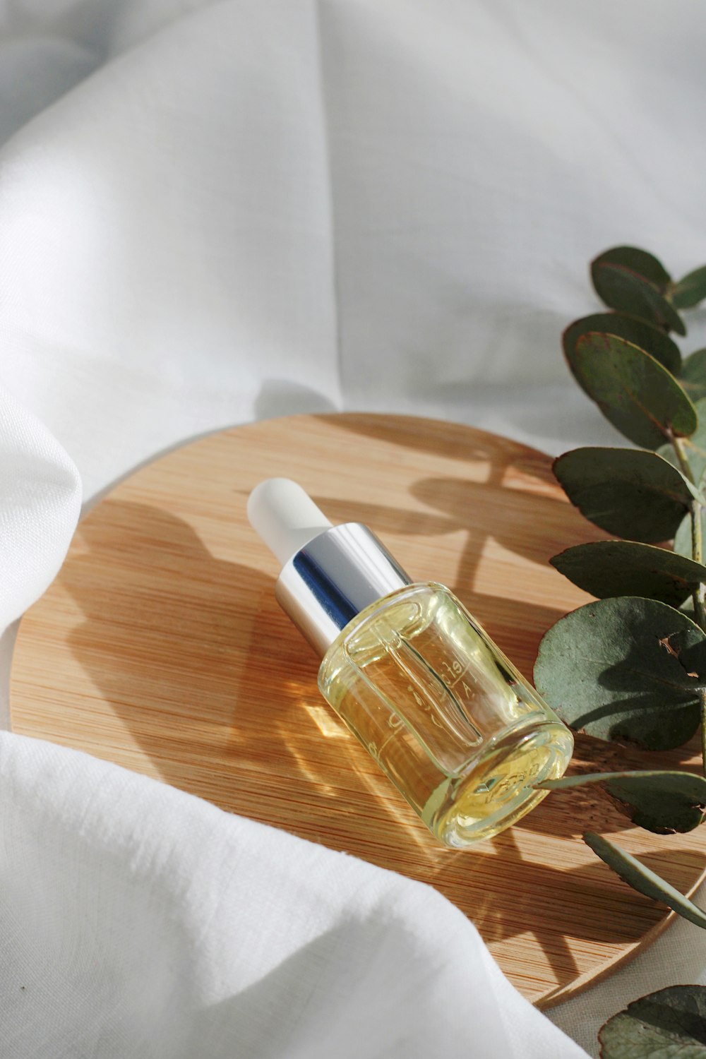 clear glass bottle on white textile