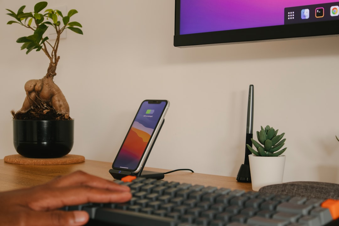 person holding iphone 6 near black computer keyboard