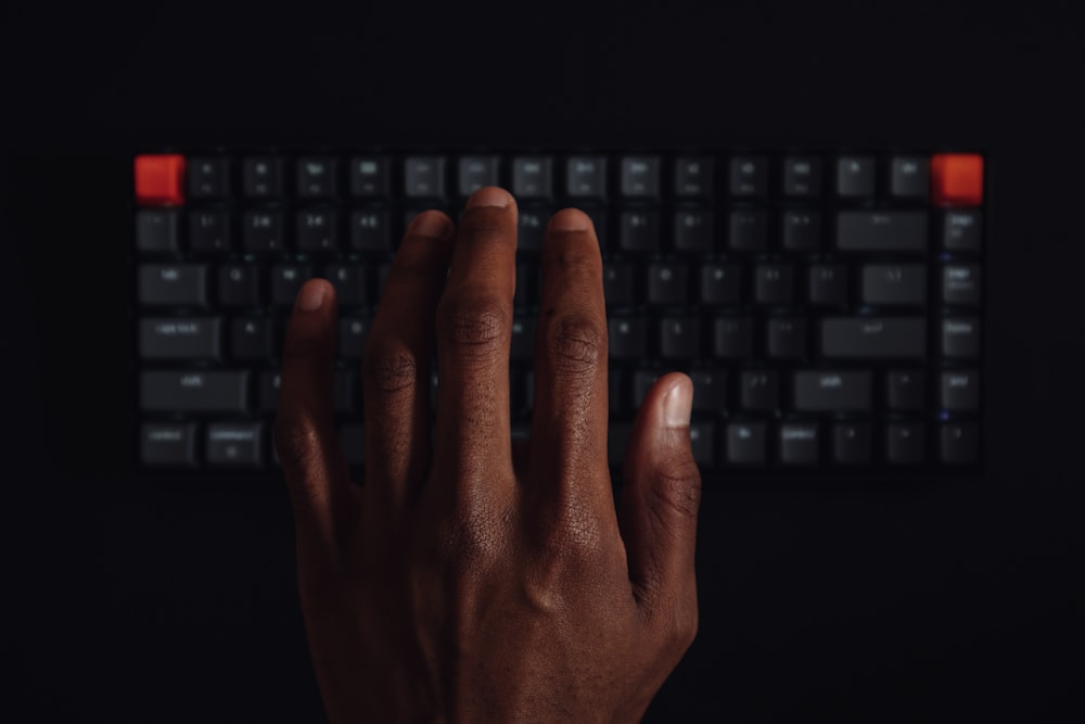 persons hand on black computer keyboard