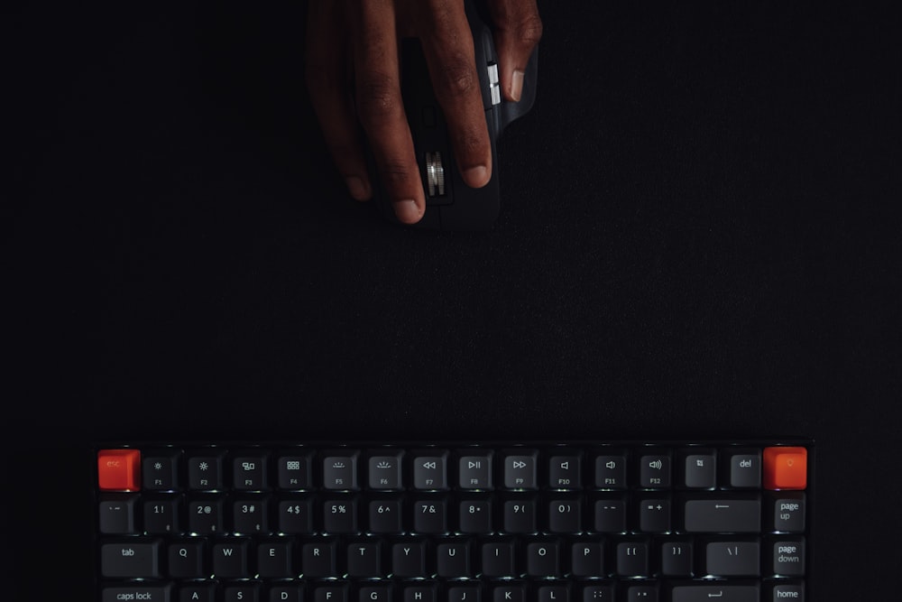 mano de personas en teclado negro de la computadora