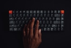 persons hand on black computer keyboard