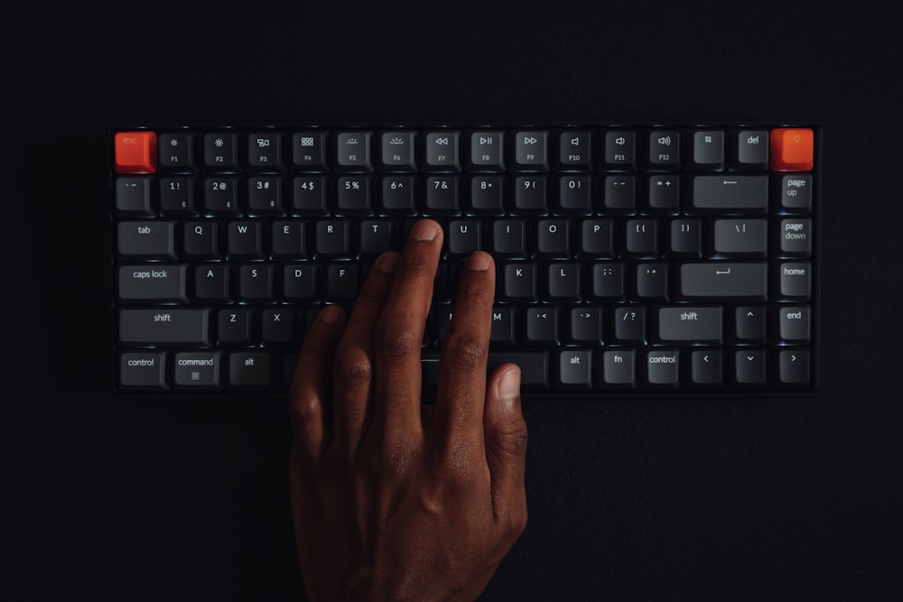 persons hand on black computer keyboard
