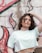 girl in white crew neck t-shirt standing near wall with graffiti during daytime