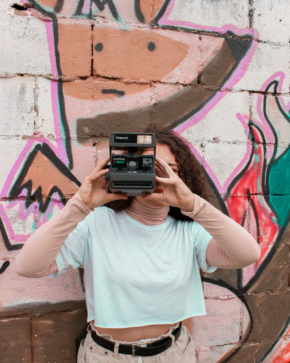 woman in white crew neck t-shirt holding black camera
