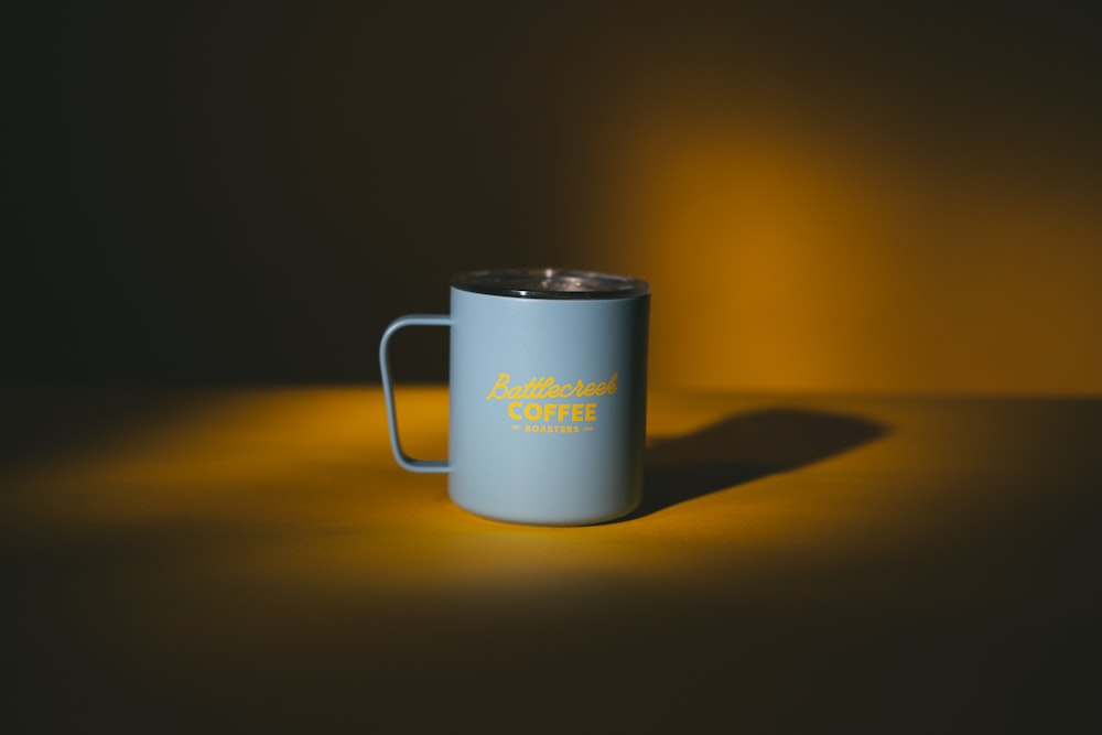 white ceramic mug on brown table