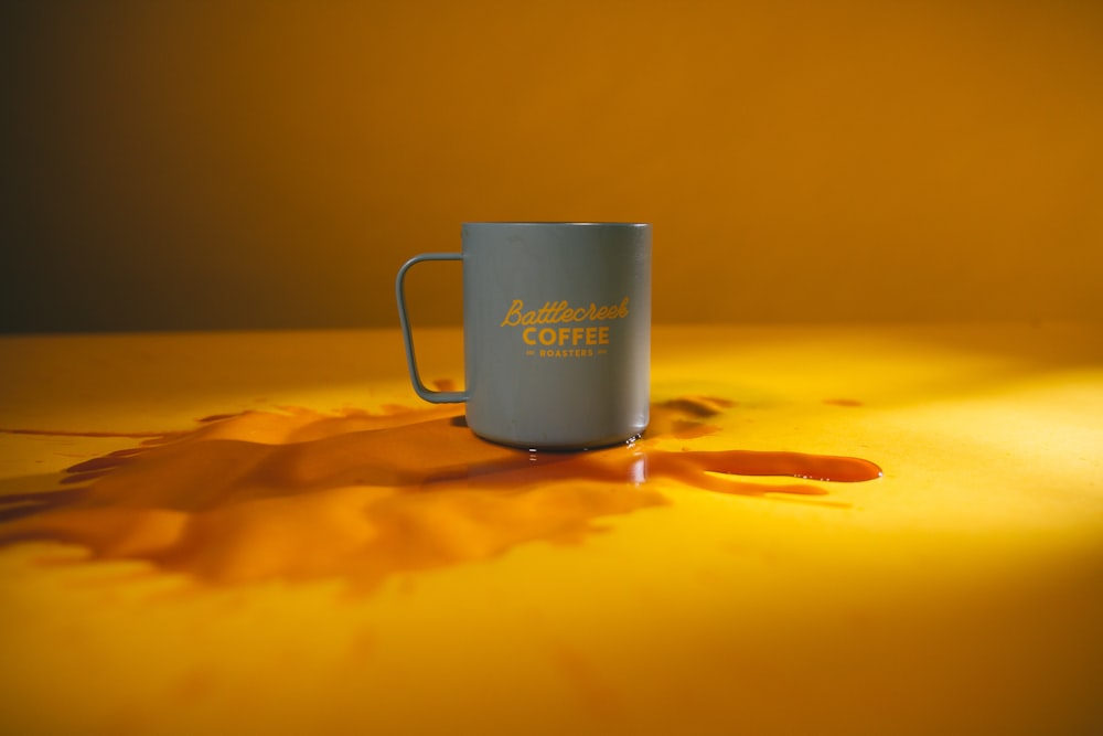 white ceramic mug on brown sand