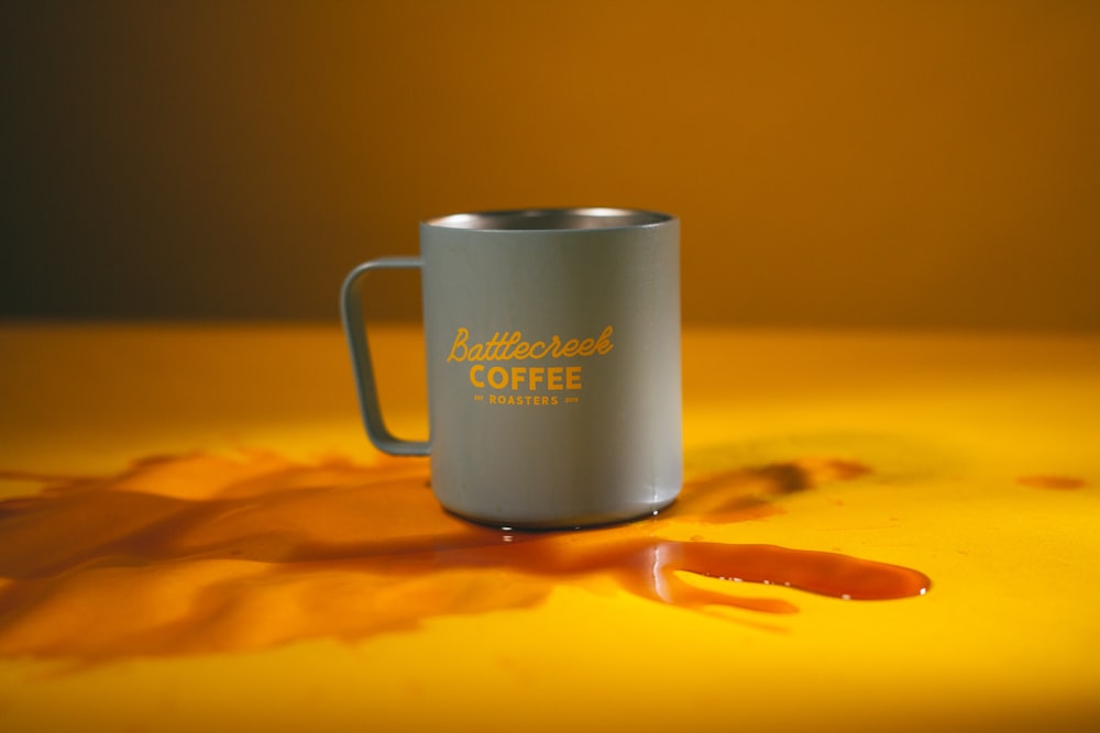 white ceramic mug on orange surface