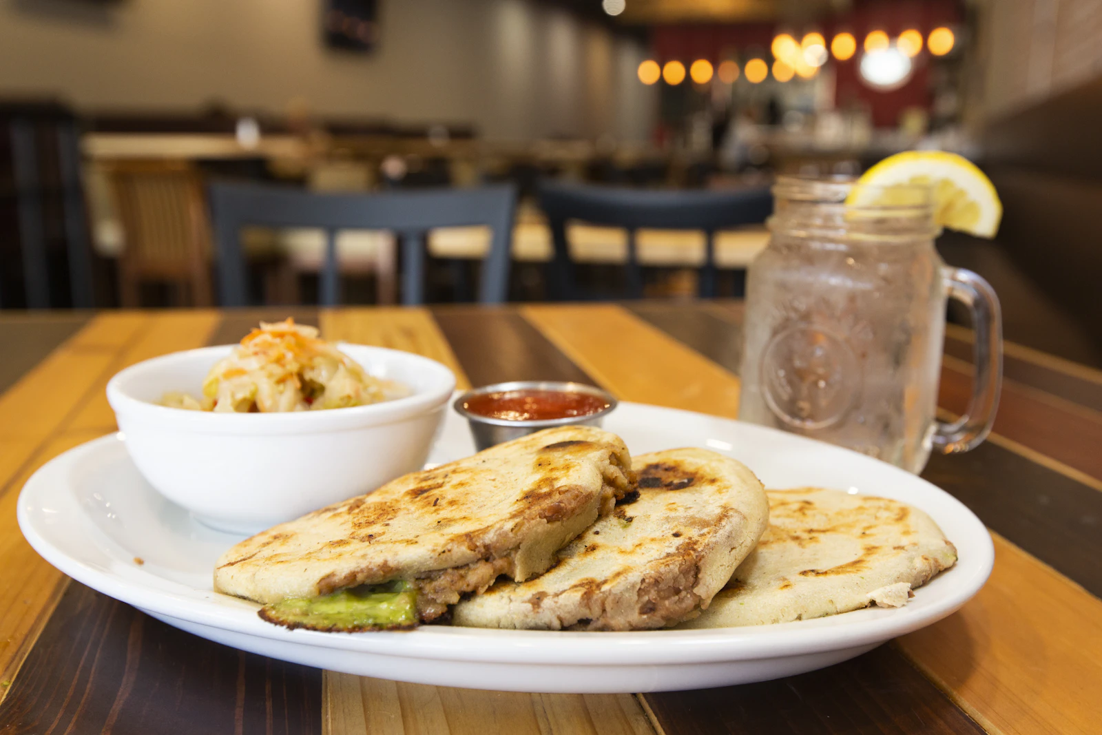 Pupusas salvadoreñas servidas en plato sobre mesa de madera, El Salvador