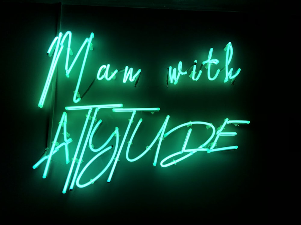 a neon sign that says man with attitude