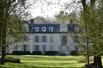 white and black concrete house near bare trees during daytime