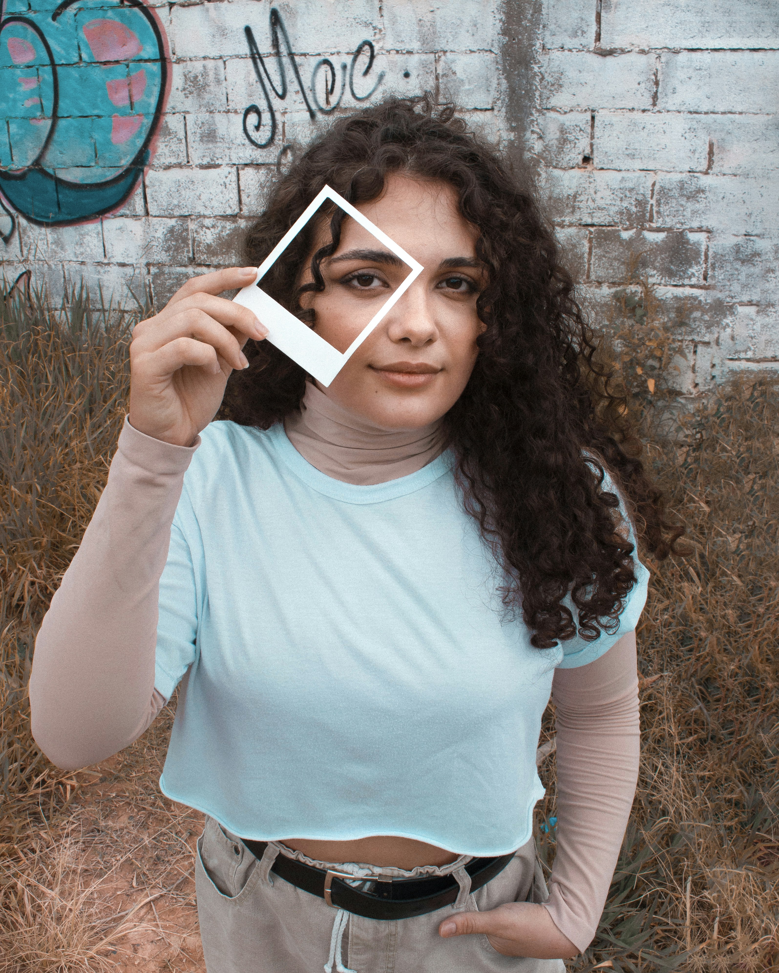 Wanita dengan kaos leher kru teal memegang buku putih