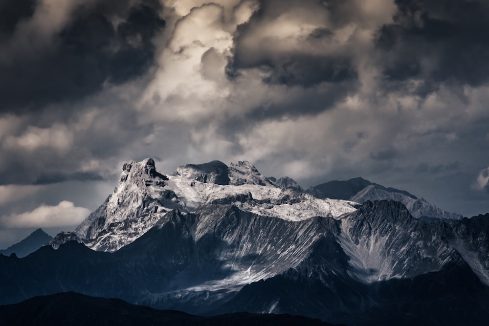 snow covered mountain under cloudy sky during daytime