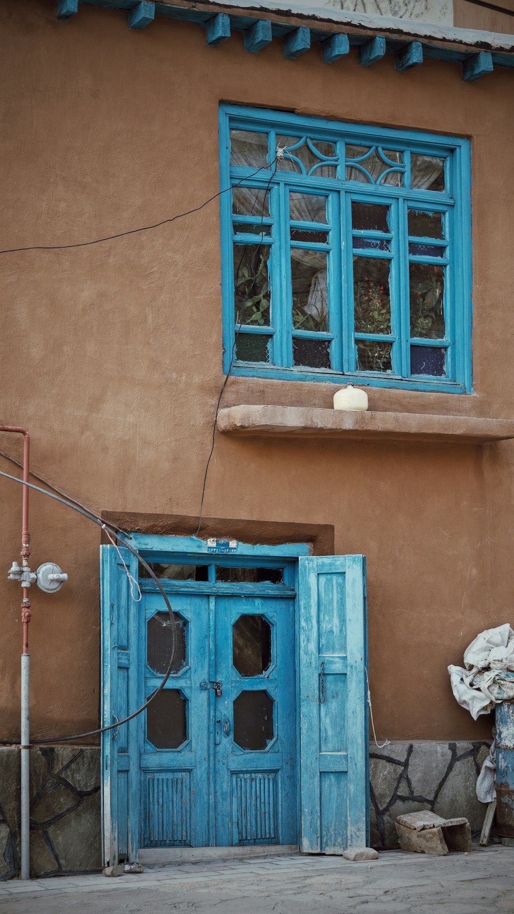 茶色のコンクリートの建物に青い木製のドア